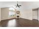 Bright living room featuring a fireplace, large window, hardwood floors, ceiling fan and vaulted ceiling at 15104 Harvest Ridge Ln, Alpharetta, GA 30022