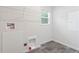Functional laundry area features gray tile flooring, storage shelves, and utility connections at 1924 Browns Mill Se Rd, Atlanta, GA 30315