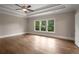 A well-lit bedroom with hardwood floors, a ceiling fan and a tray ceiling at 4900 Kentwood Dr, Marietta, GA 30068