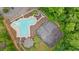 An aerial view showcases a community pool and tennis court surrounded by dense trees at 7505 Antique Barn Ave, Cumming, GA 30041
