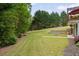 Expansive backyard featuring lush greenery, stone terraces, and a tranquil setting perfect for outdoor enjoyment at 7505 Antique Barn Ave, Cumming, GA 30041