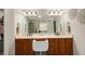 Double vanity bathroom with wood cabinets, a large mirror and chair at 7505 Antique Barn Ave, Cumming, GA 30041