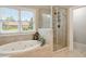Bright bathroom featuring a jetted tub, glass shower and large window with view at 7505 Antique Barn Ave, Cumming, GA 30041