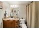 Cozy bathroom with a granite vanity, decorative mirror, and a shower with a beige curtain at 7505 Antique Barn Ave, Cumming, GA 30041
