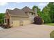 Charming home boasts a two-car garage, stone accents, and lush landscaping at 7505 Antique Barn Ave, Cumming, GA 30041