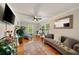 Inviting living room with a cozy gray sofa, hardwood floors, and a large window offering natural light at 7505 Antique Barn Ave, Cumming, GA 30041