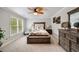 Bright main bedroom featuring a ceiling fan, carpet floors, and neutral-toned walls for a serene retreat at 7505 Antique Barn Ave, Cumming, GA 30041