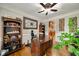 Home office with hardwood floors, wooden desk, bookcase, and decorative wall art at 7505 Antique Barn Ave, Cumming, GA 30041
