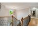 Upstairs hall with wooden railing, chandelier and hardwood floors at 7505 Antique Barn Ave, Cumming, GA 30041