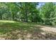 Spacious backyard featuring lush lawn, mature trees, and ample shade, perfect for outdoor activities and relaxation at 8136 Connally Dr, Douglasville, GA 30134