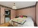 Charming bedroom with soft pink walls and patterned wallpaper border; adjacent kitchen access at 8136 Connally Dr, Douglasville, GA 30134