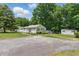 Charming single-story home with blue shutters, a fenced yard, and a storage shed located on a spacious lot at 8136 Connally Dr, Douglasville, GA 30134
