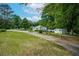 Landscaped property featuring a charming single-story home with blue shutters, a storage shed, and a long driveway at 8136 Connally Dr, Douglasville, GA 30134