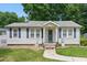 Charming single story home featuring a cozy front porch and blue shutters surrounded by a beautifully landscaped yard at 8136 Connally Dr, Douglasville, GA 30134