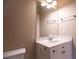 Bathroom with a mirror over a white single sink vanity with storage and chrome accents at 319 Barbados Ln, Suwanee, GA 30024