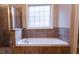 Bathroom featuring tile enclosed tub with shower and a window at 319 Barbados Ln, Suwanee, GA 30024