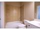 Cozy bathroom with tan tile shower and tub combination, with a white toilet and vanity at 319 Barbados Ln, Suwanee, GA 30024