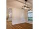 Dining area shows hardwood floors, wainscoting, and decorative lighting fixture at 319 Barbados Ln, Suwanee, GA 30024
