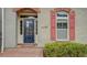 Close up of the front entrance featuring red brick stairs and gray brick and red shutters on the home at 319 Barbados Ln, Suwanee, GA 30024