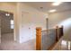 Upstairs hallway with carpet, wooden railing and views into bedrooms and the downstairs entrance at 319 Barbados Ln, Suwanee, GA 30024