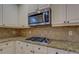 Stylish kitchen features granite countertops, a gas range, and stainless steel microwave at 319 Barbados Ln, Suwanee, GA 30024
