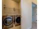 Laundry room with modern front load washer and dryer and overhead storage shelving at 319 Barbados Ln, Suwanee, GA 30024