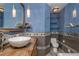 Contemporary blue bathroom showcasing a vessel sink, wooden vanity, mosaic tiles, and floating shelves at 625 Kennesaw Ave, Atlanta, GA 30308