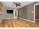 Bedroom with hardwood floors, neutral and accent walls, a TV, and glass door leading to a balcony at 625 Kennesaw Ave, Atlanta, GA 30308