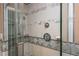 Modern bathroom shower featuring glass doors, dual shower heads, and tiled walls with decorative trim at 625 Kennesaw Ave, Atlanta, GA 30308