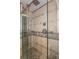 Modern bathroom shower featuring glass doors, dual shower heads, and tiled walls with decorative trim at 625 Kennesaw Ave, Atlanta, GA 30308