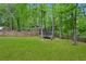 Spacious backyard featuring a trampoline, surrounded by lush greenery and a wooden fence at 6250 Vista Crossing Way, Cumming, GA 30028