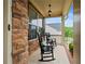 Inviting covered front porch with rocking chairs and stone accent wall at 6250 Vista Crossing Way, Cumming, GA 30028
