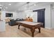 Spacious game room with a pool table, TV, modern light fixture, and cozy seating at 6250 Vista Crossing Way, Cumming, GA 30028