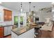 Open kitchen with granite counters, stainless appliances, and island seating overlooking the living area at 6250 Vista Crossing Way, Cumming, GA 30028