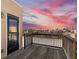 A spacious wooden balcony with a railing boasts beautiful city skyline views against a vibrant sunset sky at 791 Wylie Se St # 912, Atlanta, GA 30316