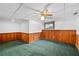 Spacious basement rec room with wood paneling and neutral-colored carpet at 1498 Camp Point Ne Ct, Roswell, GA 30075