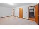 Open bedroom with carpeted floor, closet, and a door leading to a wooden staircase at 1498 Camp Point Ne Ct, Roswell, GA 30075