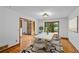 Bright dining room with wood floors, a large window with backyard views, and stylish modern furniture at 1498 Camp Point Ne Ct, Roswell, GA 30075