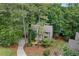 Aerial view of a two-story home with lush landscaping, mature trees, and a winding driveway at 1498 Camp Point Ne Ct, Roswell, GA 30075