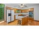 Bright kitchen features wood cabinets, stainless steel appliances and center island cooktop at 1498 Camp Point Ne Ct, Roswell, GA 30075
