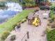 Aerial view of a playground area next to the lake, featuring slides, swings, and picnic tables at 1498 Camp Point Ne Ct, Roswell, GA 30075
