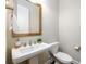 Chic half-bath features pedestal sink, stylish fixtures, and a decorative mirror at 2080 Abbey Rd, Roswell, GA 30076