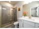 Bright bathroom with a glass enclosed shower, tile surround, and vanity with white countertop at 2080 Abbey Rd, Roswell, GA 30076