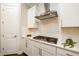 Close-up of modern kitchen with stainless steel range, tile backsplash, and white cabinetry at 2080 Abbey Rd, Roswell, GA 30076