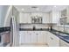 Modern kitchen featuring white cabinets, black granite countertops, and stainless steel appliances at 4060 Haverhill Ne Dr # F, Atlanta, GA 30342