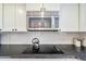 Modern kitchen with stainless steel microwave, black cooktop on granite counter, and white cabinets at 4060 Haverhill Ne Dr # F, Atlanta, GA 30342
