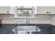 Close-up of a kitchen sink with black granite countertop and a stainless steel faucet under a window at 4060 Haverhill Ne Dr # F, Atlanta, GA 30342