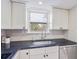 Bright kitchen with white cabinets, black granite countertops, and a stainless steel sink and appliances at 4060 Haverhill Ne Dr # F, Atlanta, GA 30342