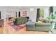 Open living area features an olive green sofa, natural light, colorful rug and hardwood floors at 4060 Haverhill Ne Dr # F, Atlanta, GA 30342
