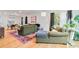 Open living area features an olive green sofa, natural light, colorful rug and hardwood floors at 4060 Haverhill Ne Dr # F, Atlanta, GA 30342